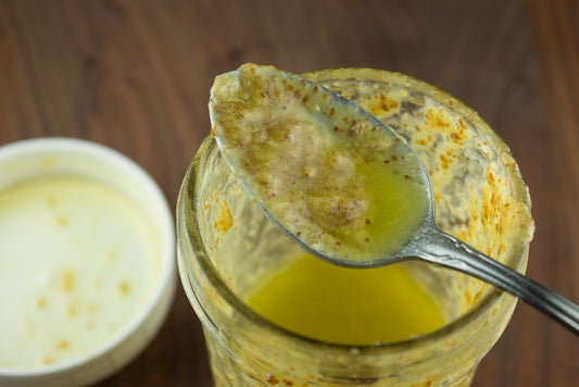 spoon of honey mustard over jar