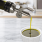 stainless steel pour spout on a bottle of avocado oil pouring oil into a ramekin 