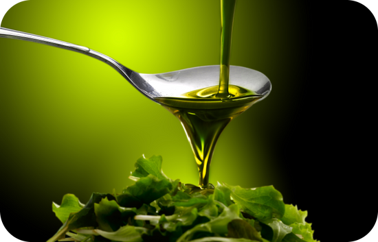 oil spilling on a spoon then dripping on the salad leaves