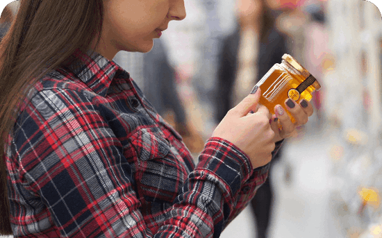 girl reading label on a honey jar