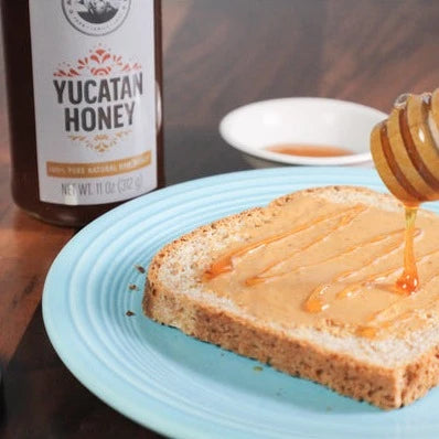 Ava Jane's Kitchen's Yucatan honey being drizzled on a piece of peanut butter toast